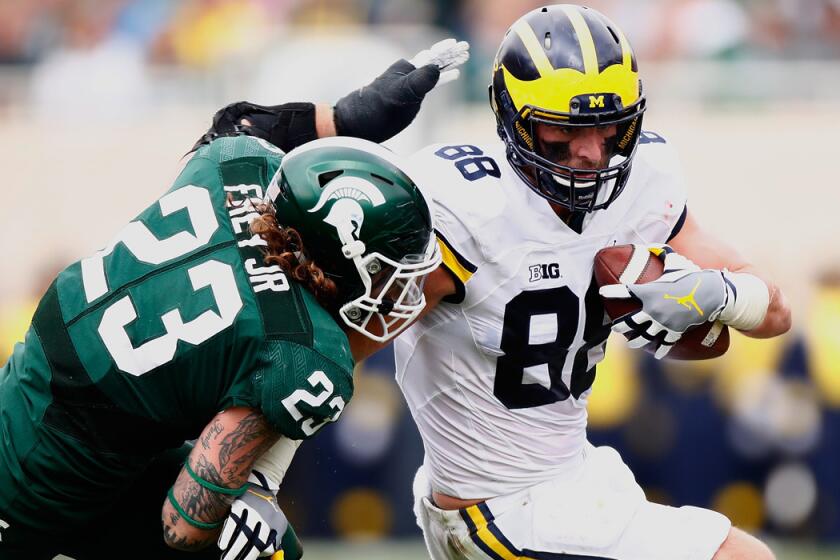 Michigan's Jake Butt, left, looks to get around the tackle of Michigan State's Chris Frey after a third-quarter catch Saturday.