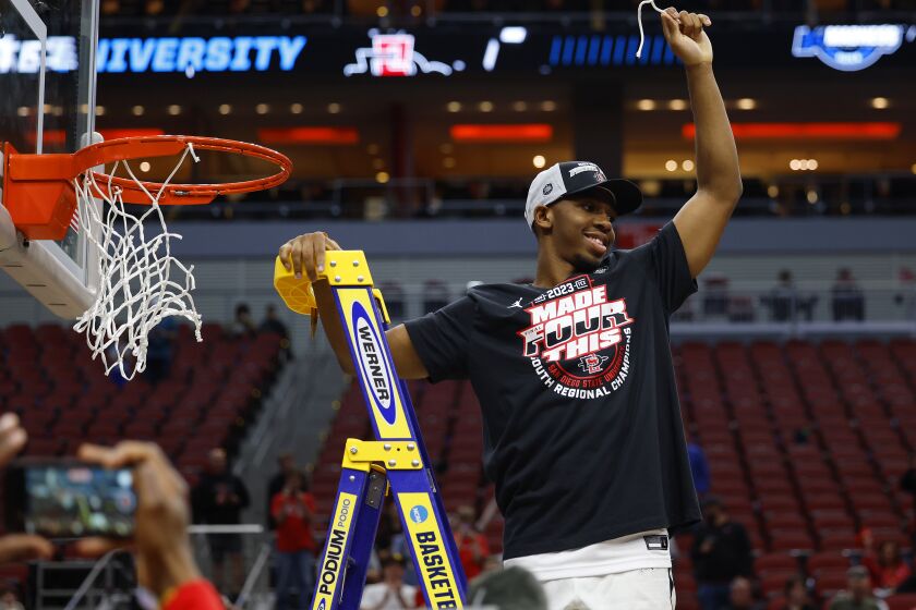 Louisville, KY - March 26: San Diego State's Lamont Butler cuts down the net after the Aztecs beat Creighton 57-56 in an Elite 8 game in the NCAA Tournament on Sunday, March 26, 2023 in Louisville, KY. (K.C. Alfred / The San Diego Union-Tribune)