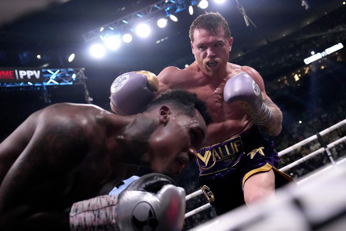 Canelo Álvarez, top, punches Jermell Charlo during their super middleweight title fight at T-Mobile Arena.