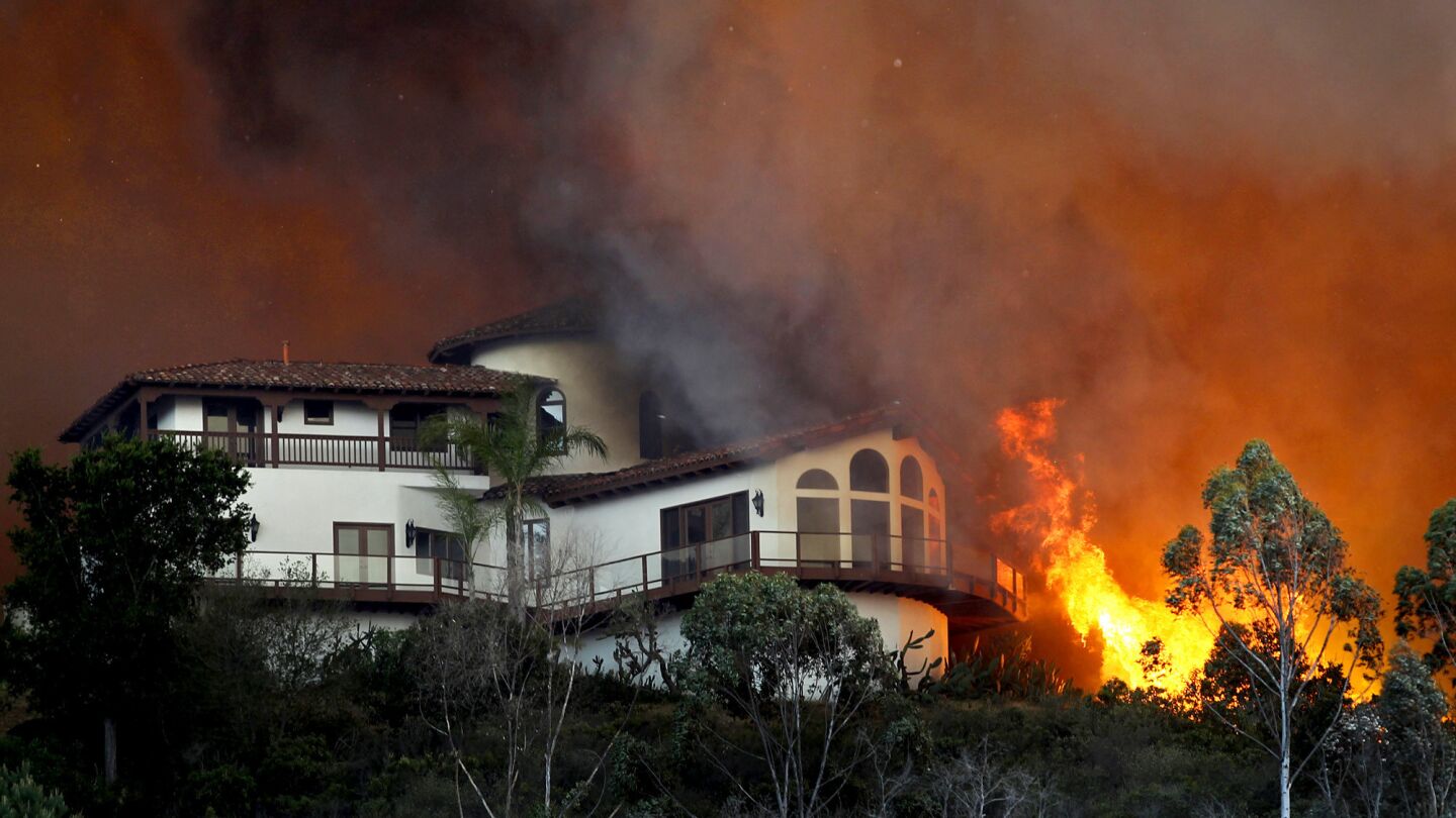 Flames surround a large hilltop home near Cal State San Marcos that caught fire.