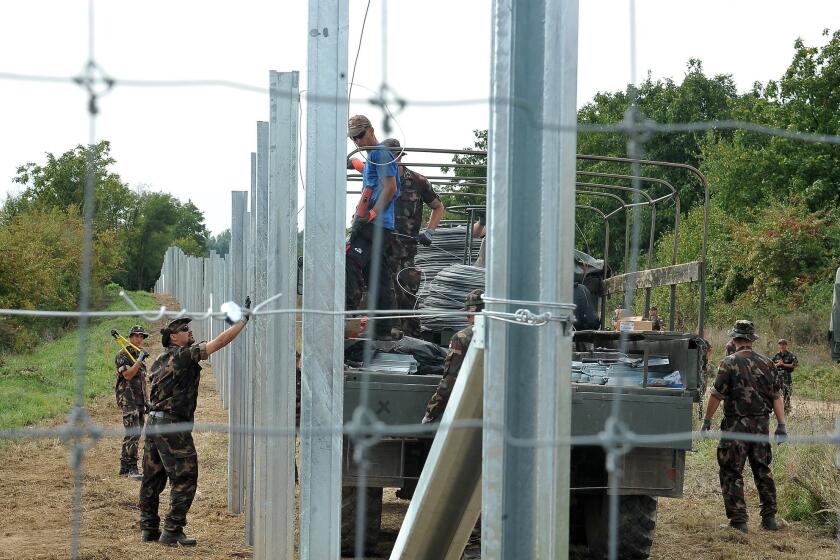 Hungarian soldiers raise fences at the border with Croatia on Sept. 22.