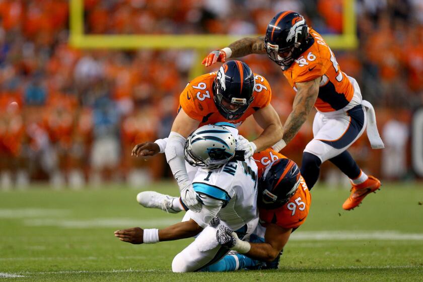 Panthers quarterback Cam Newton (1) is hit by Broncos defenders Derek Wolfe (95) and Jared Crick (93) in the first quarter at Sports Authority Field at Mile High.
