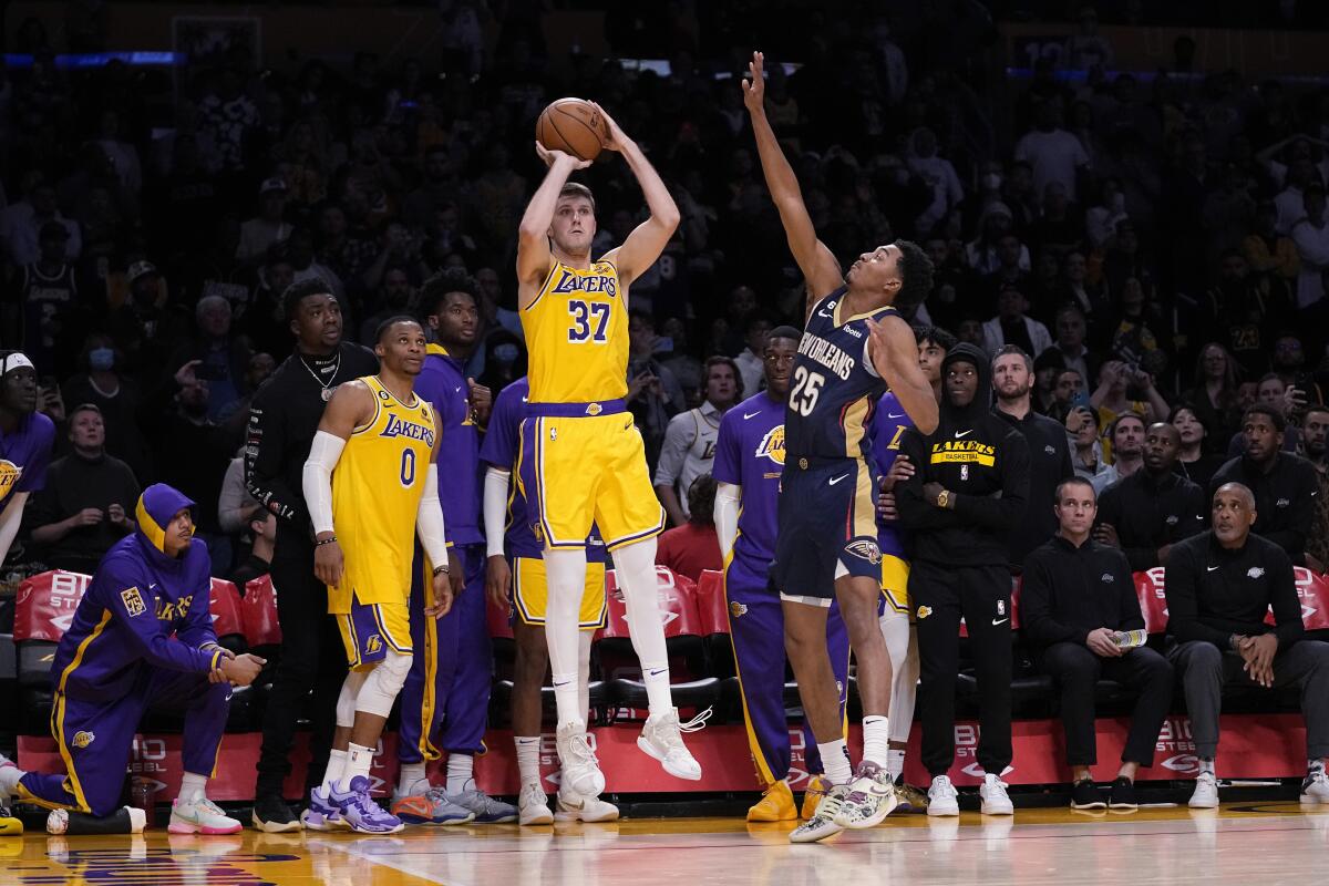 Lakers' Matt Ryan makes a three-point shot to send the game to overtime as New Orleans Pelicans' Trey Murphy III defends.