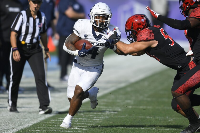 Utah State running back Calvin Tyler Jr. (4) is pushed out of bounds by San Diego State linebacker Caden McDonald (54) in the first half during an NCAA college football game for the Mountain West Conference Championship, Saturday, Dec. 4, 2021, in Carson, Calif. (AP Photo/John McCoy)