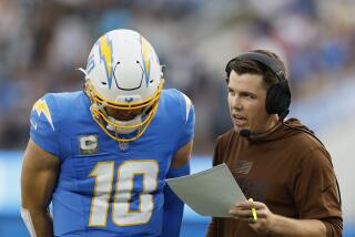  Chargers offensive coordinator Kellen Moore talks with quarterback Justin Herbert.