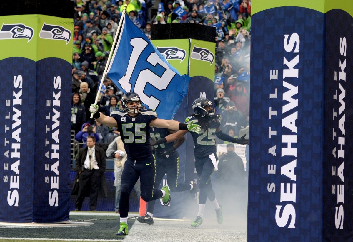 Seattle linebacker Heath Farwell runs out of the Seahawks' tunnel with the 12th Man flag before an NFC Divisional playoff game against the New Orleans Saints at CenturyLink Field on Jan. 11.