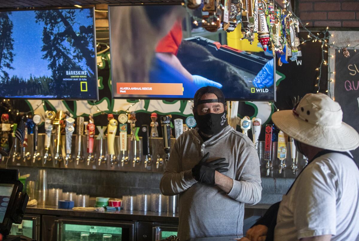 Jim Rafferty, owner of Kelly's Korner — one of Orange County's best-known sports bars — chats with a regular on May 16 in Placentia.