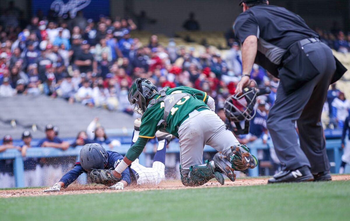 In a close play at the plate, catcher Jaylen Thomas of Narbonne tags Daniel Canales of Garfield.
