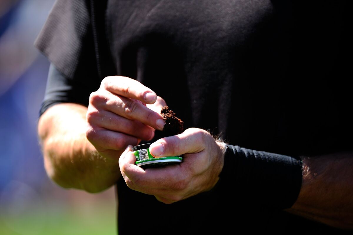 Mark DeRosa of the San Francisco Giants uses smokeless tobacco during warmups prior to playing the Los Angeles Dodgers at Dodger Stadium on March 31, 2011.