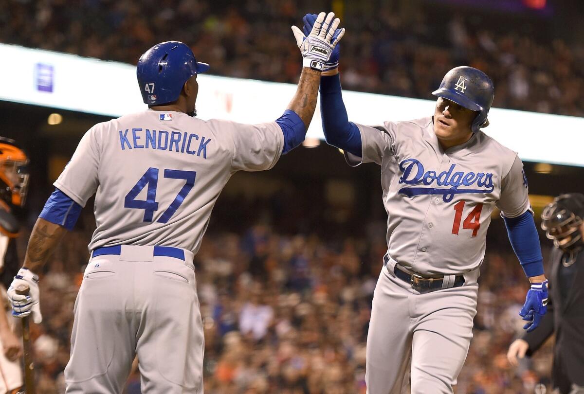 Enrique Hernandez, right, is congratulated by Howie Kendrick hitting a solo home run against San Francisco on Tuesday.