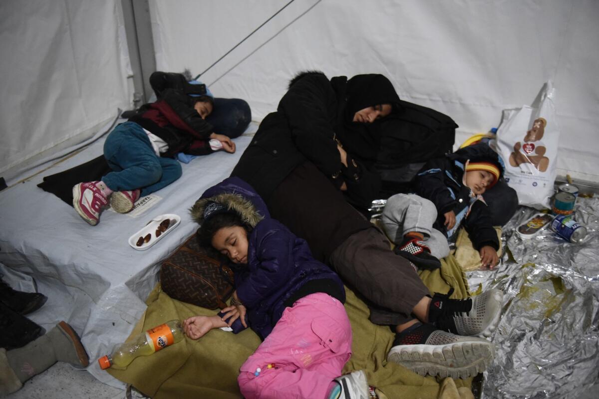 Una madre duerme con sus hijos dentro de una tienda de campaña en un campamento para refugiados. Miles de inmigrantes que huyen de la guerra buscan llegar a países europeos prósperos como Alemania, Austria y Suecia. (Foto AP/Giannis Papanikos)