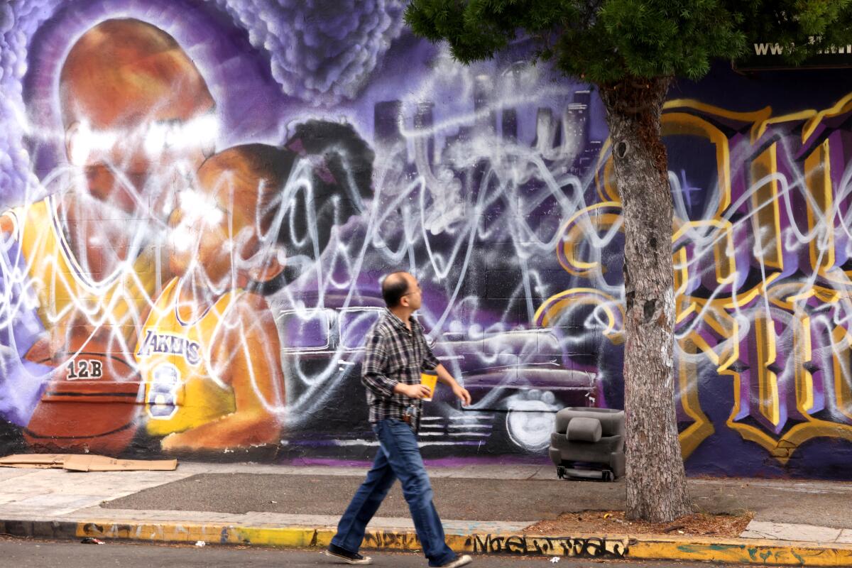 James Bang looks over a mural of Kobe and Gianna Bryant that has been vandalized again at 14th and Main streets in L.A.