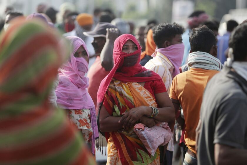 Migrant laborers from other states looking for work gather on a street on the outskirts of Jammu, India, Sunday, Sept.27, 2020. The nation of 1.3 billion people is expected to become the coronavirus pandemic's worst-hit country within weeks, surpassing the United States. (AP Photo/Channi Anand)