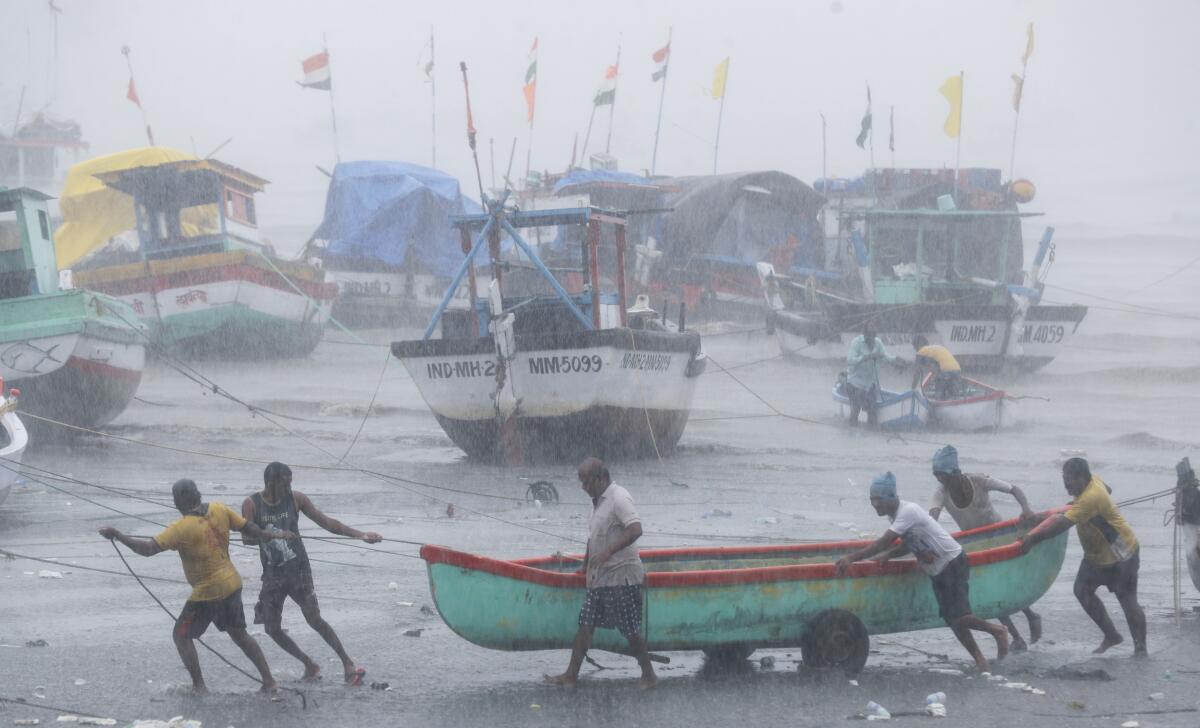 Fishermen try to move a boat to safer ground in Mumbai, India, on May 17, 2021.