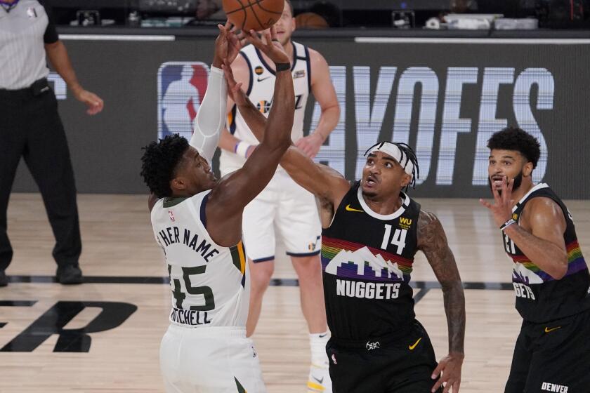 Utah Jazz's Donovan Mitchell (45) attempts a shot over Denver Nuggets' Gary Harris.