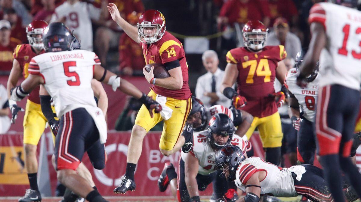 USC quarterback Sam Darnold leaps over the Utah defense during a drive in the fourth quarter at the Coliseum on Saturday. USC won 27-28.