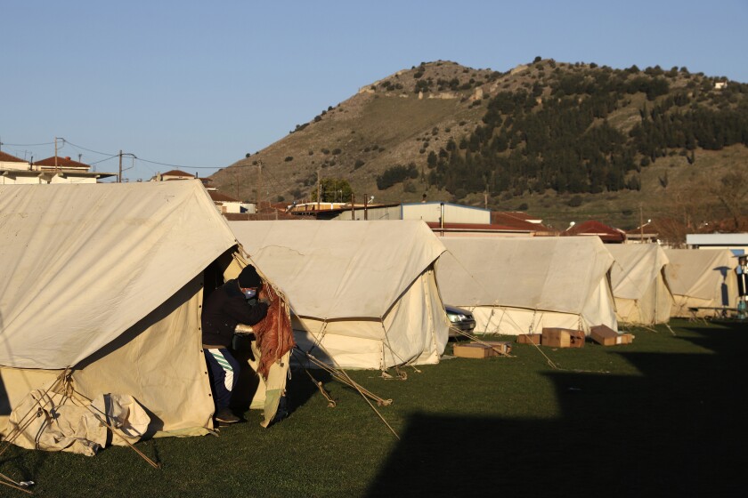 A man exits from a tent at a soccer field after an earthquake in Damasi village, central Greece, Thursday, March 4, 2021. Fearful of returning to their homes, thousands of people in central Greece spent the night outdoors after a powerful earthquake, felt across the region, damaged homes and public buildings. (AP Photo/Vaggelis Kousioras)