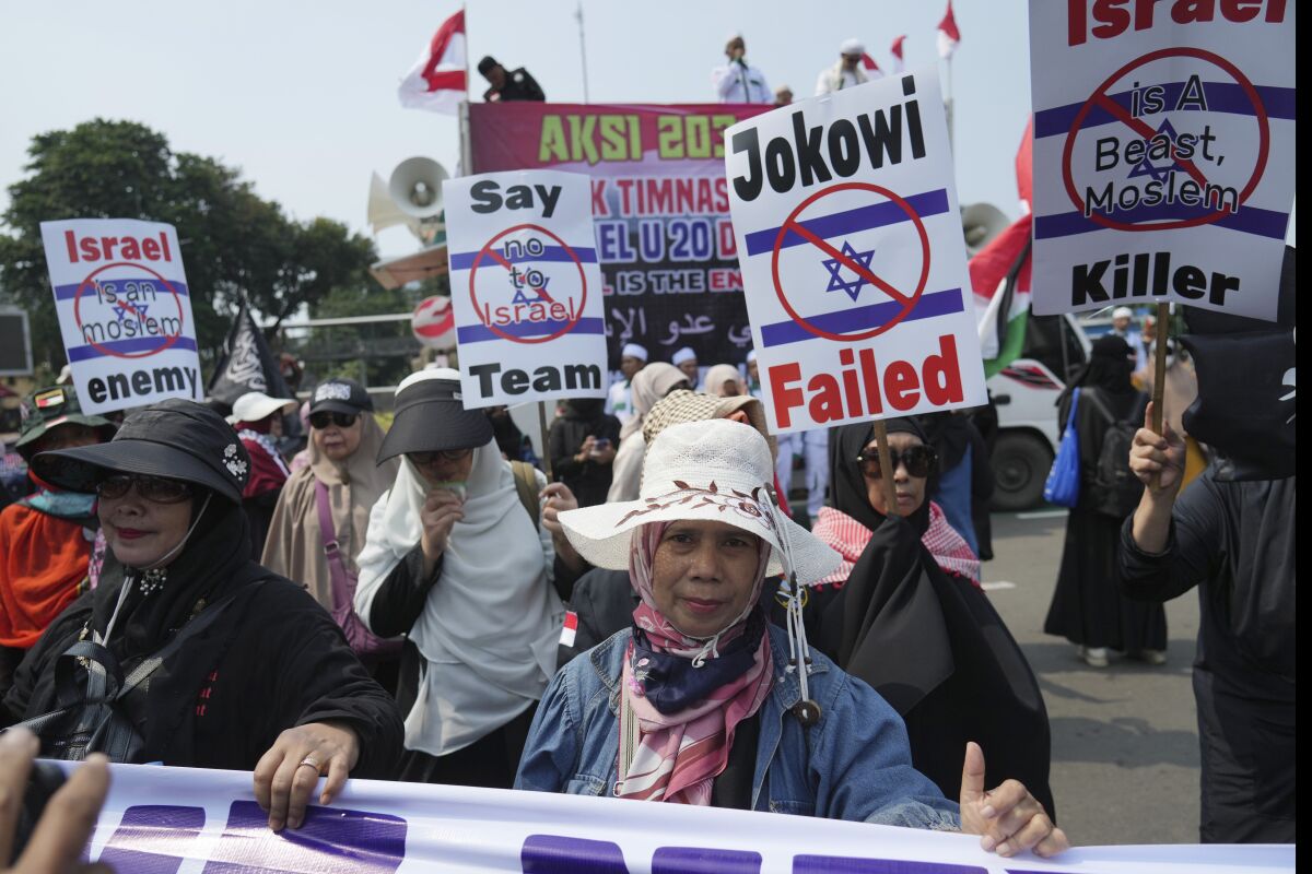 Protesters march during a protest in Jakarta, Indonesia, Monday, March 20, 2023. Hundreds of conservative Muslims have marched to the streets Monday in Indonesia's capital to protest against the Israeli team's participation in the FIFA World Cup Under-20 in Indonesia.(AP Photo/Achmad Ibrahim)