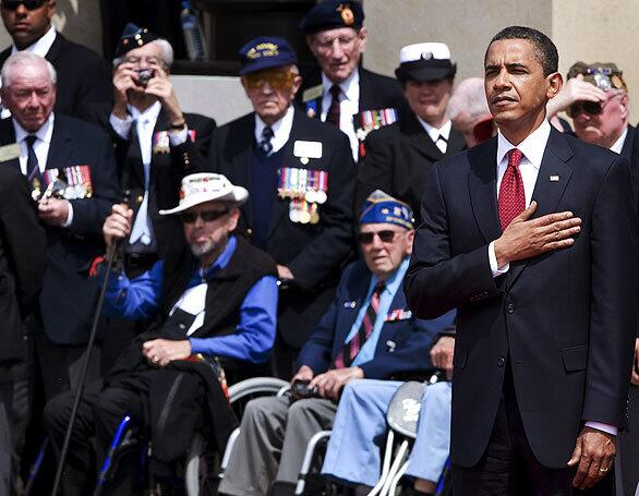 President Barack Obama stands for the American national anthem at a ceremony at the U.S. war cemetery in Colleville-Sur-Mer, in Normandy, to mark the 65th anniversary of the Allied beach landings during World War II.