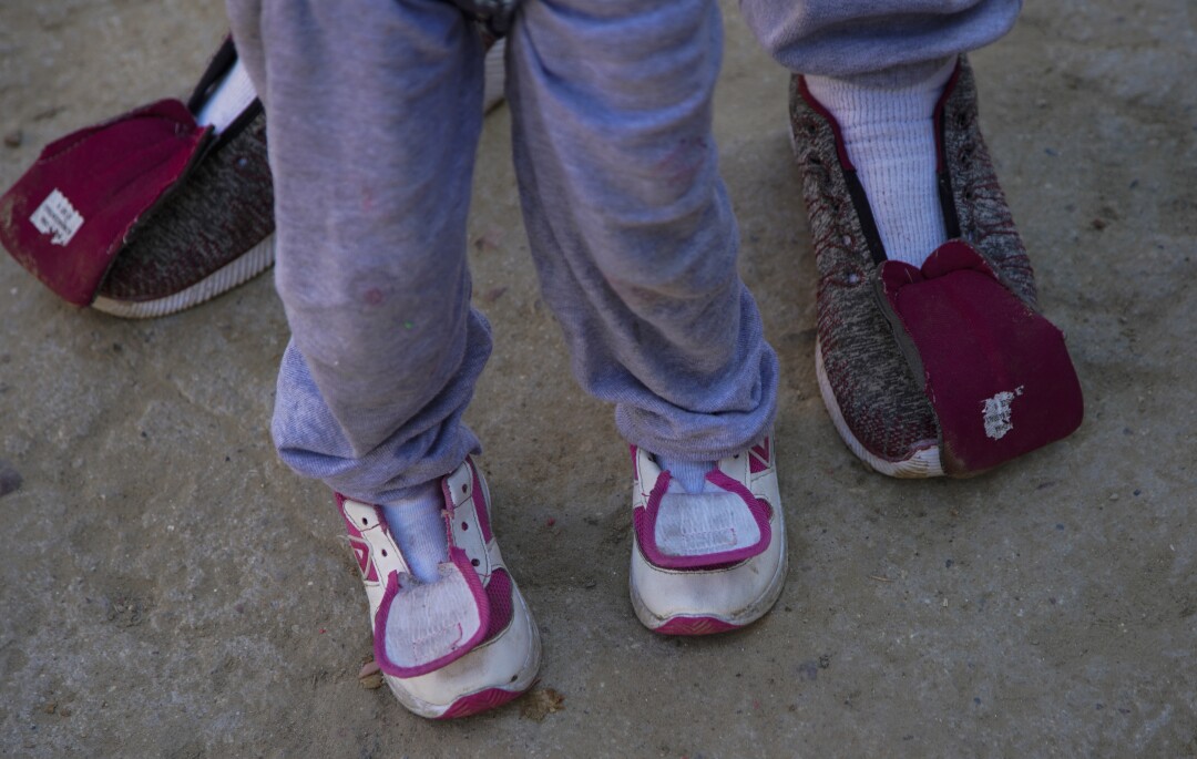 Shoes on asylum seekers' feet have no shoelaces.