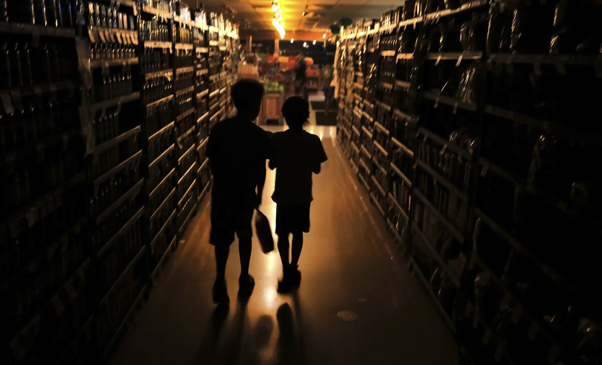 Elijah Carter and Robert Haralson shop in an Olivers Supermarket on Oct. 23, 2019, in a blackout in Santa Rosa, Calif. 