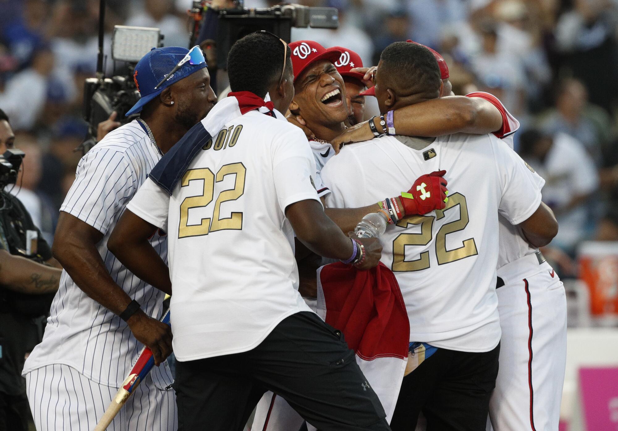 Juan Soto is swarmed by teammates after his derby triumph.