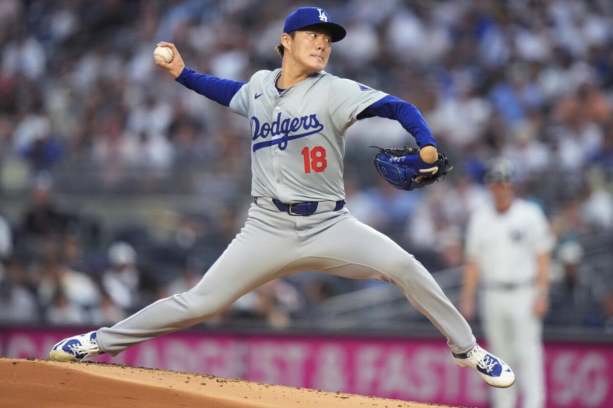 Dodgers right-hander Yoshinobu Yamamoto holds a four-seam grip while pitching in a gray away uniform, No. 18
