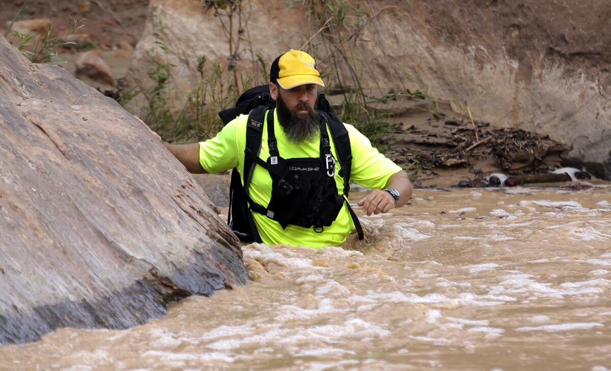 A member of a search and rescue team wades in the Virgin River during a search in Zion National Park, near Springdale, Utah. Seven hikers who entered a narrow desert canyon for a day of canyoneering became trapped when a flash flood filled the chasm with water, killing at least five of them.