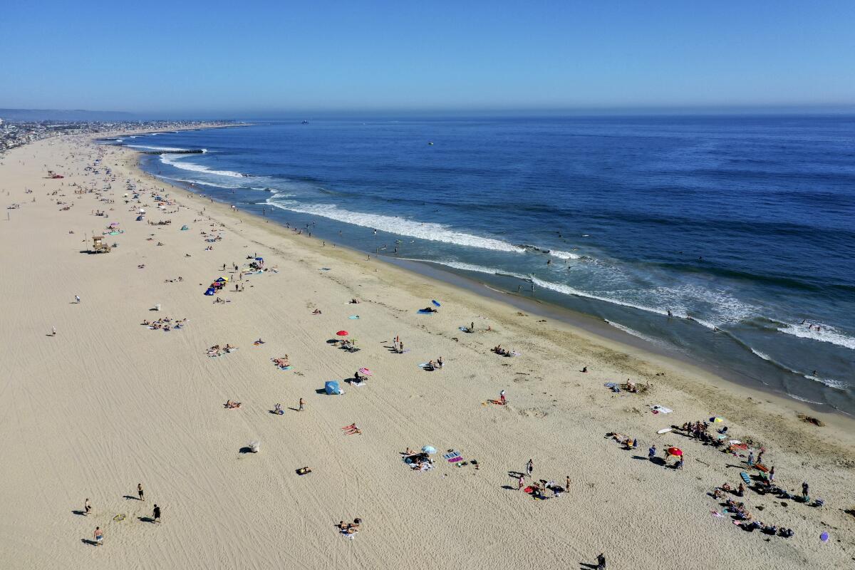 An aerial view shows beachgoers scattered on the sand in Newport Beach on April 25.