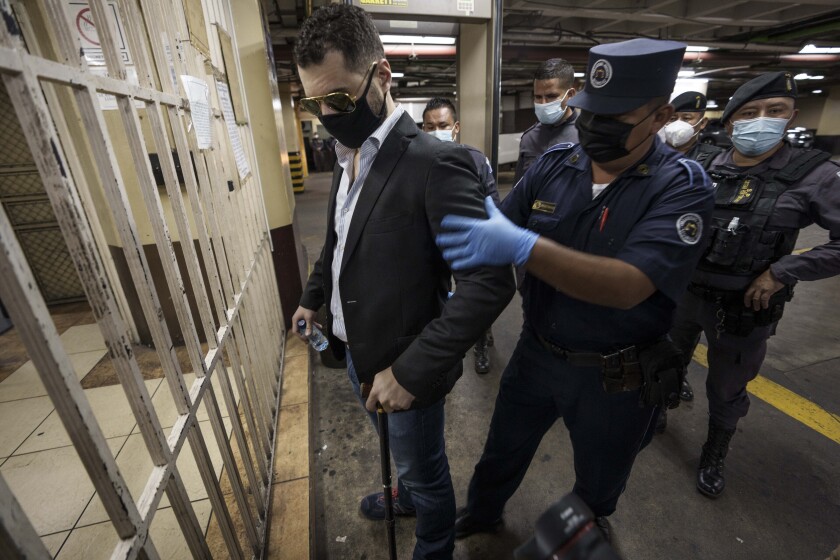 FILE - Ricardo Alberto Martinelli Linares, left, son of former Panama's President Ricardo Martinelli, is checked by police as he arrives to court for a hearing in Guatemala City, Monday, Nov. 8, 2021. Linares pleaded guilty Tuesday, Dec. 14, 2021 in New York to laundering $28 million in connection with a massive bribery scheme involving a Brazil-based global construction conglomerate. (AP Photo/Moises Castillo, File)