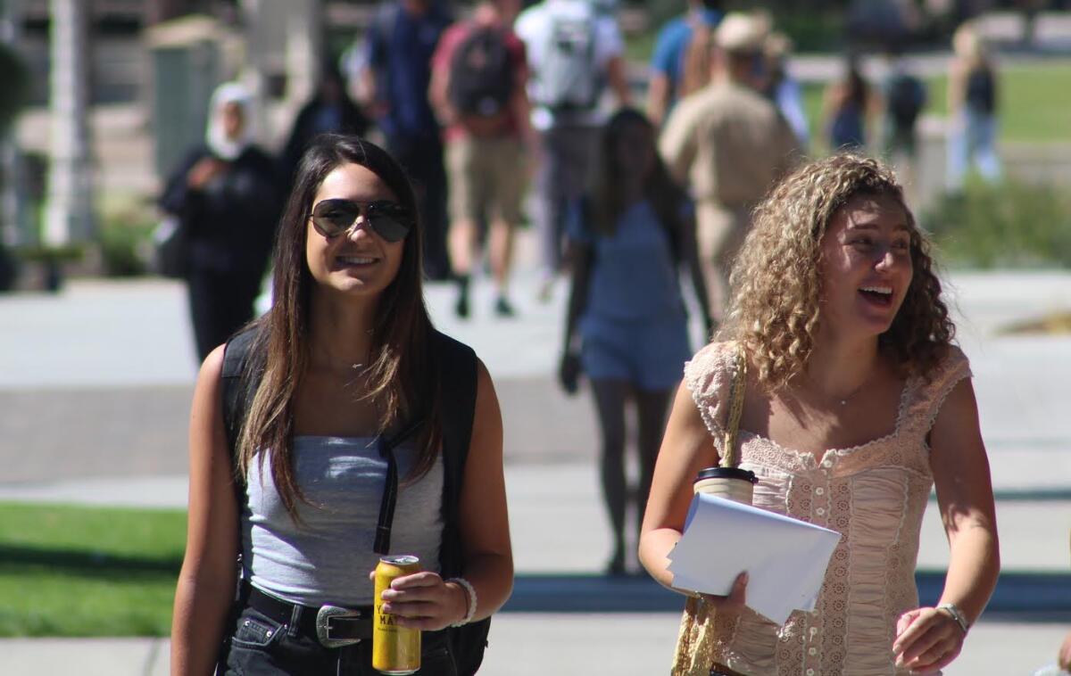 Two people walking on a college campus