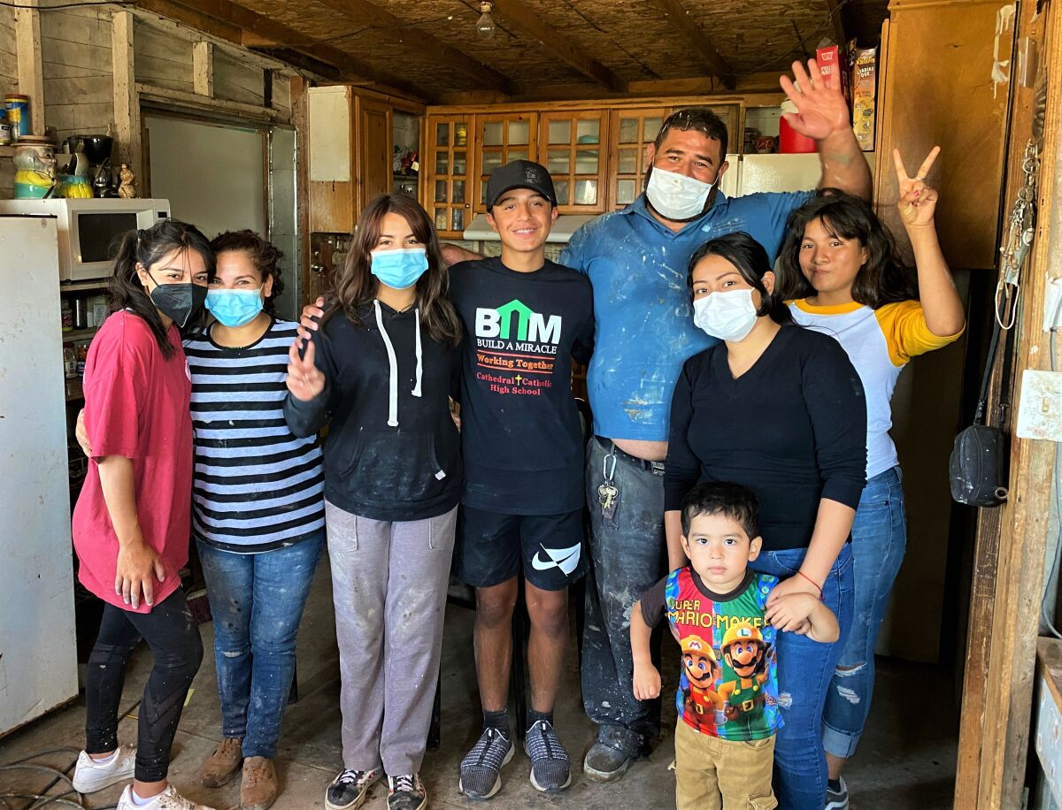 Daniella Benítez y Gabriel posan con una familia de Tijuana cuya casa empezaron a construir 