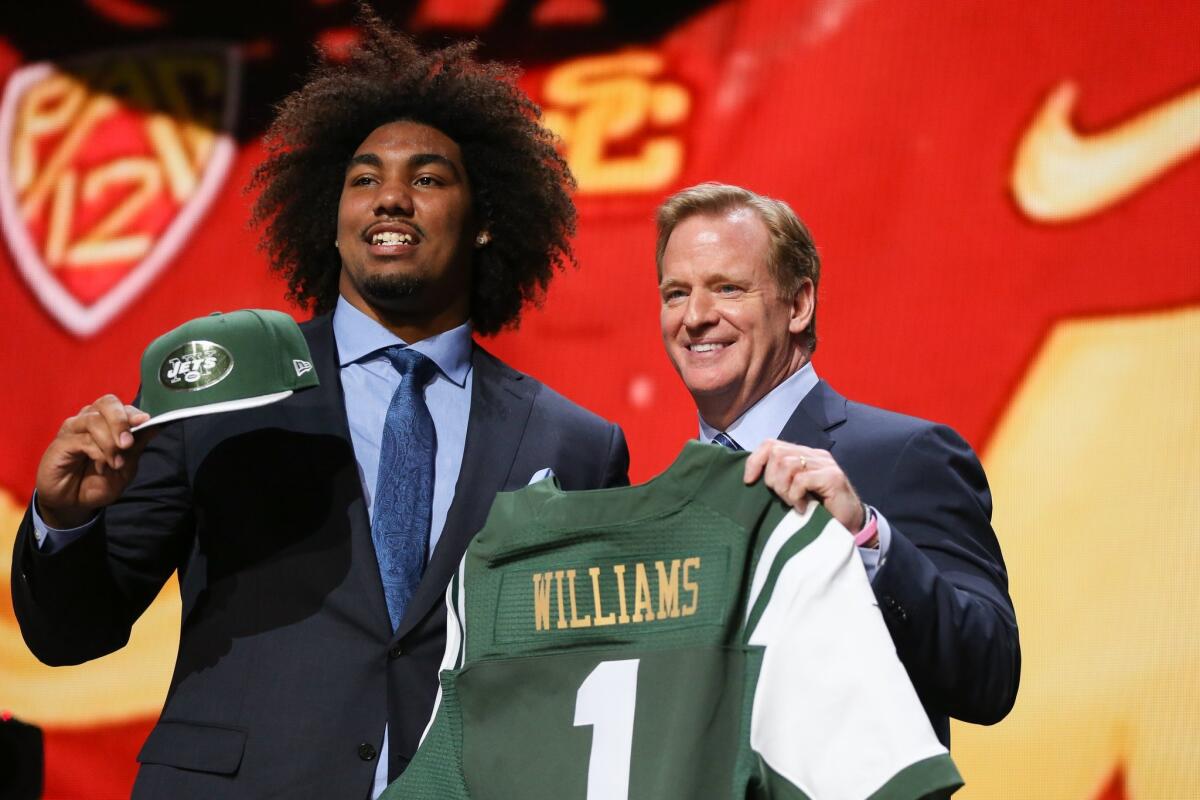 Former USC Trojan Leonard Williams holds up a jersey with NFL Commissioner Roger Goodell after being chosen No. 6 overall by the New York Jets during the first round of the 2015 NFL draft on Thursday night.