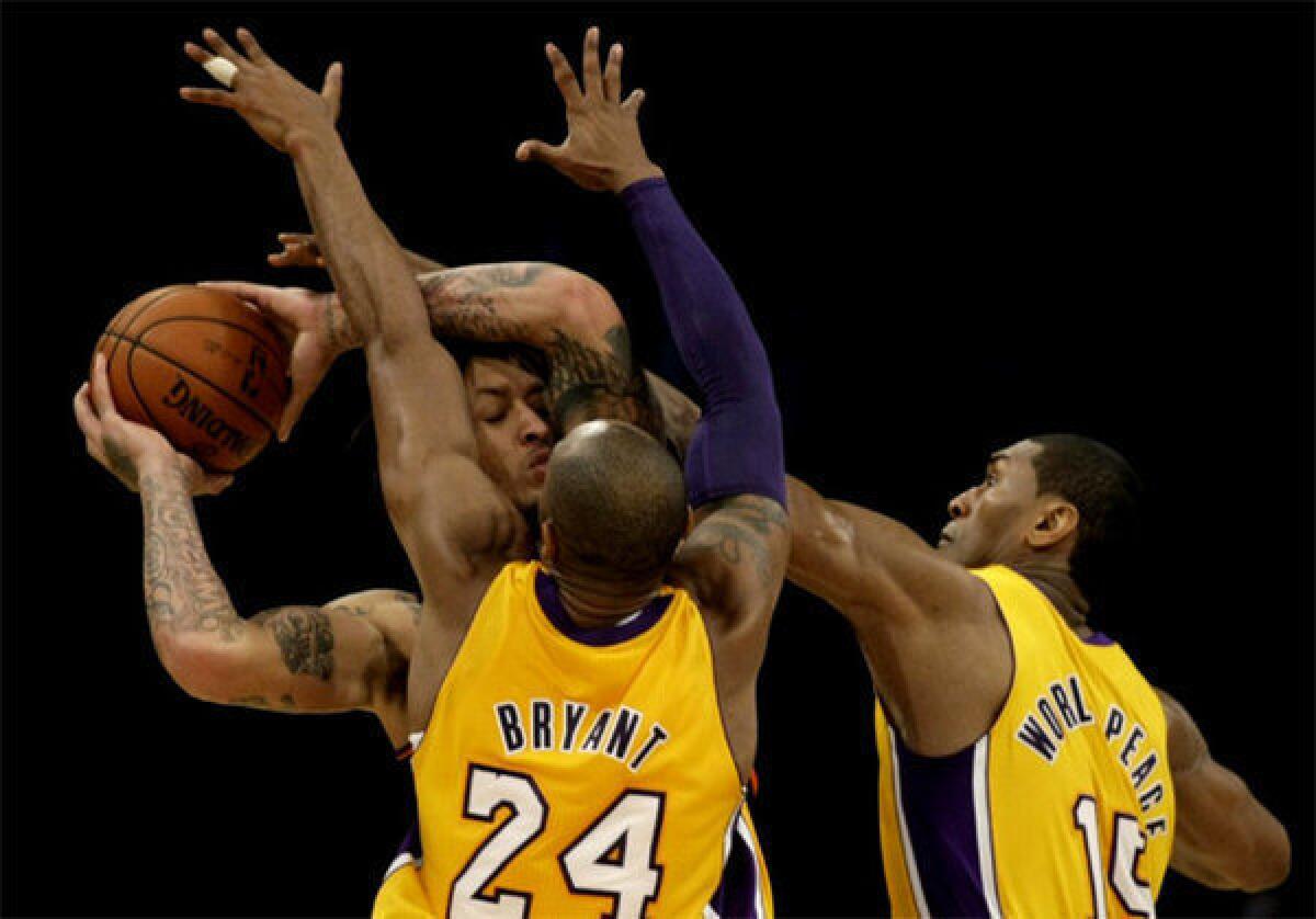 Kobe Bryant and Metta World Peace apply pressure to Phoenix Suns forward Michael Beasley.
