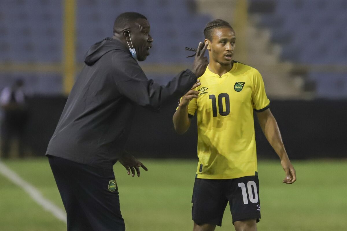Jamaica's coach Theodore Whitmore, left, gives instructions to Bobby Reid during a qualifying soccer match against El Salvador for the FIFA World Cup Qatar 2022 at Cuscatlan stadium in San Salvador, El Salvador, Friday, Nov. 12, 2021. (AP Photo/Salvador Melendez)