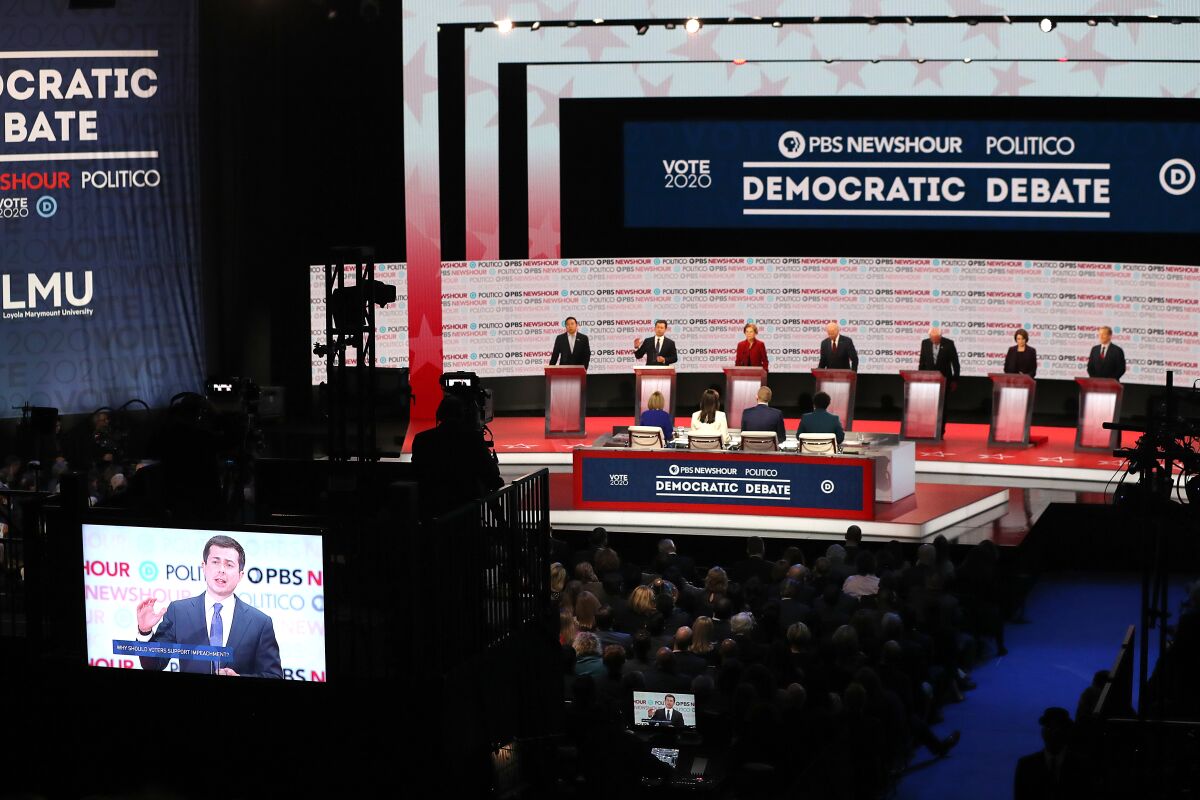 Pete Buttigieg speaks as former Andrew Yang, Elizabeth Warren, Bernie Sanders, Amy Klobuchar and Tom Steyer, from left, listen during the Democratic presidential primary debate in Los Angeles. 