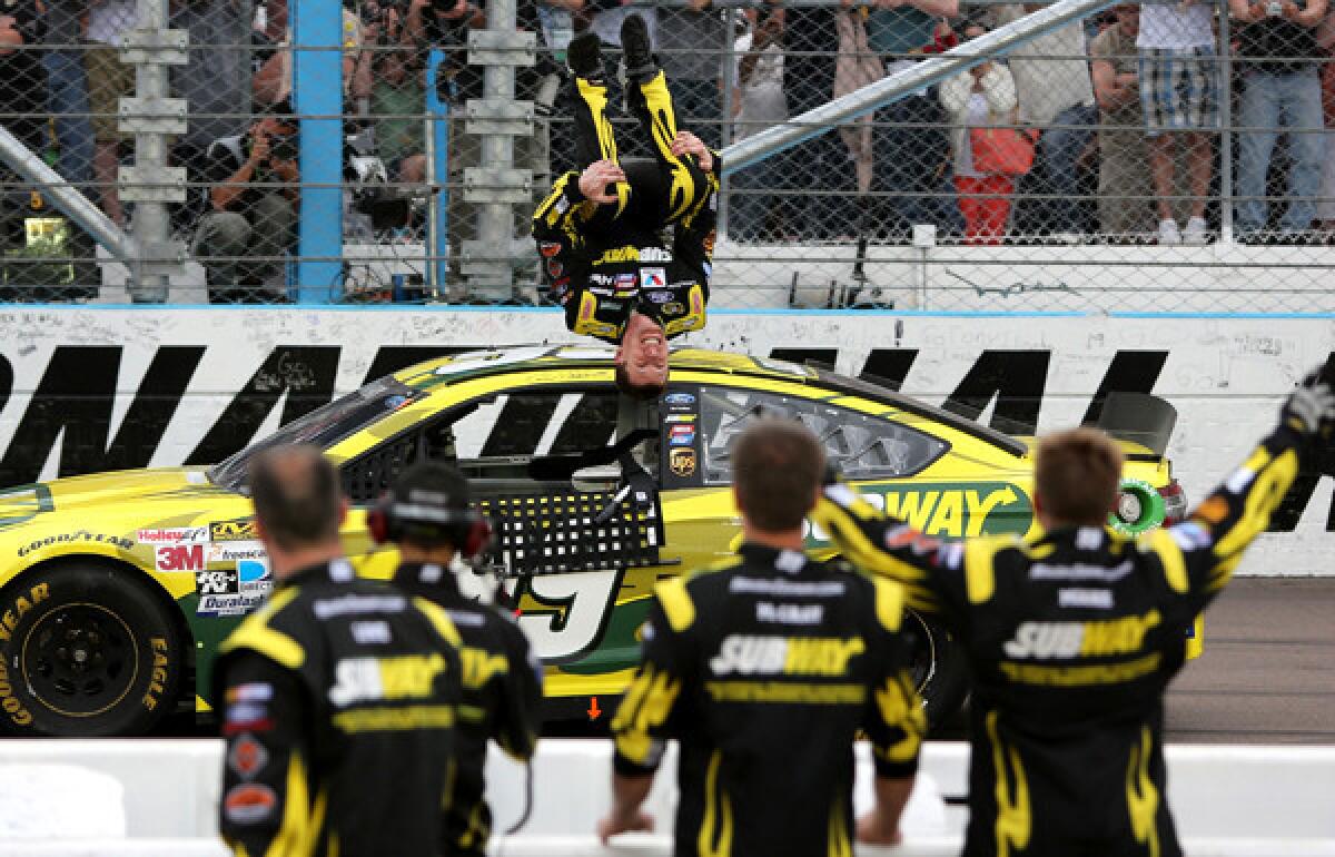 NASCAR driver Carl Edwards performs his trademark backflip after winning the Sprint Cup Series race at Phoenix International Raceway on Sunday.
