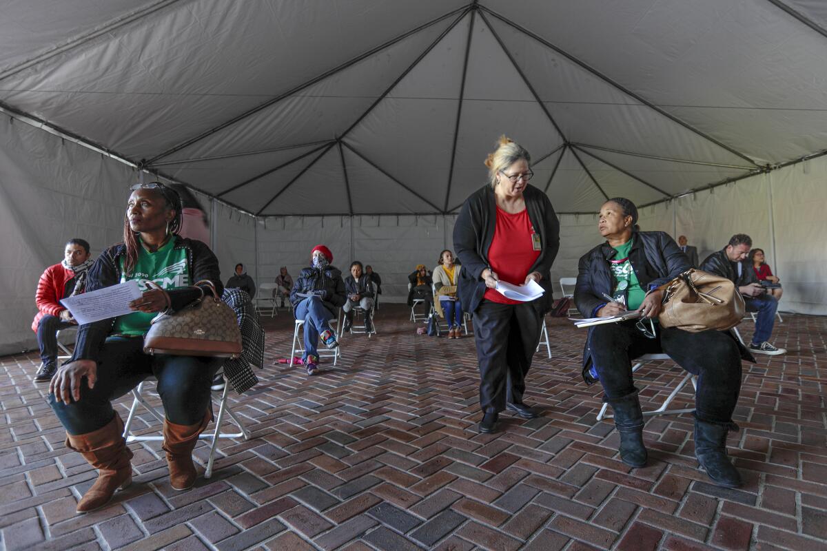 With City Hall closed to the public, Los Angeles residents watch a livestream of a City Council meeting from a tent outside. Seats are spread out to facilitate social distancing.