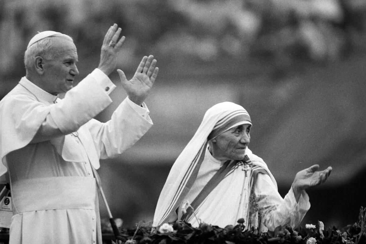 Mother Teresa and Pope John Paul II wave to well-wishers at the Nirmal Hriday Home in Calcutta in February 1986.