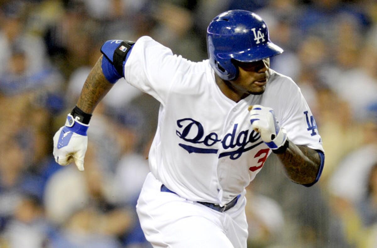 Dodgers left fielder Carl Crawford breaks toward first base on an infield single against the Detroit Tigers during a game at Dodger Stadium.