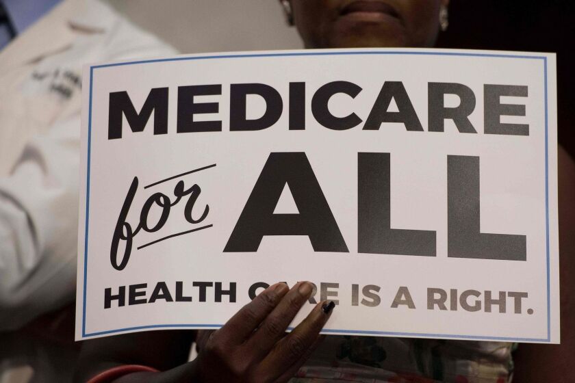 (FILES) In this file photo taken on September 13, 2017 a member of the audience holds up a placard as US Senator Bernie Sanders, Independent from Vermont, discusses Medicare for All legislation on Capitol Hill in Washington, DC. - Having a health insurance card in America is no guarantee of medical care without the risk of financial ruin. One must take care to choose a doctor or hospital that is part of a pre-approved network. Estimate how much would be paid out of pocket after hospital bills that can reach tens of thousands of dollars. And, for Americans covered by their employers, be careful about any change in jobs and try to avoid risky gaps in health insurance coverage.Vermont Senator Bernie Sanders, who came up with the idea, California Senator Kamala Harris and New York Senator Kirsten Gillibrand are among those calling for "Medicare for all," or offering everyone in the nation the type of public insurance offered to those over 65, a program in existence since the 1960s. (Photo by JIM WATSON / AFP)JIM WATSON/AFP/Getty Images ** OUTS - ELSENT, FPG, CM - OUTS * NM, PH, VA if sourced by CT, LA or MoD **