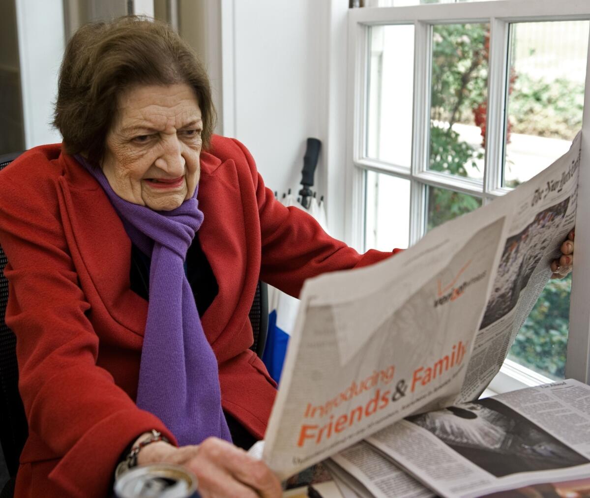 Correspondent Helen Thomas reads a newspaper inside the White House briefing room. Thomas, who was the first woman to join the White House Correspondents' Association, died July 20. She was 92.