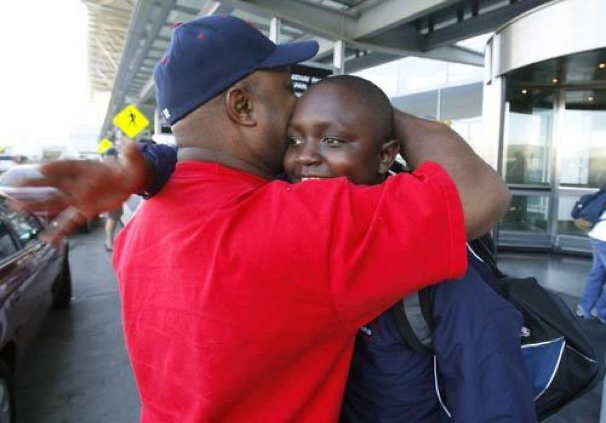 Michael Camel Jr., 12, and his father Michael Camel say goodbye as the boy leaves with his fellow San Mateo Little League teammates on a goodwill tour to Toyonaka, Japan. Michael Jr. almost didn't get to go with his team his dad couldn't afford the clothes and equipment he needed to take. The duo were homeless for six months, but the Shelter Network that helped them get off the streets helped purchase everything needed for his trip.