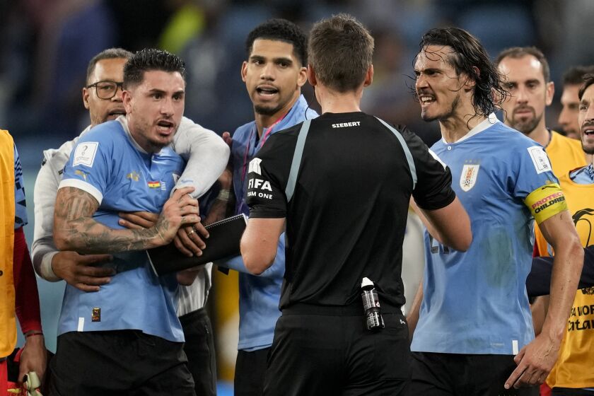 FILE - Uruguay's Edinson Cavani, right, argues with referee Daniel Siebert of Germany, at the end of a World Cup group H soccer match against Ghana at the Al Janoub Stadium in Al Wakrah, Qatar, on Dec. 2, 2022. FIFA banned Uruguay players Fernando Muslera and José María Giménez for four games each on Friday Jan. 27, 2023 for aggressively confronting match officials when the team was eliminated from the World Cup last month. Veterans Edinson Cavani and Diego Godín must also serve one-game bans when Uruguay next plays, FIFA said in announcing disciplinary verdicts. (AP Photo/Darko Vojinovic, File)