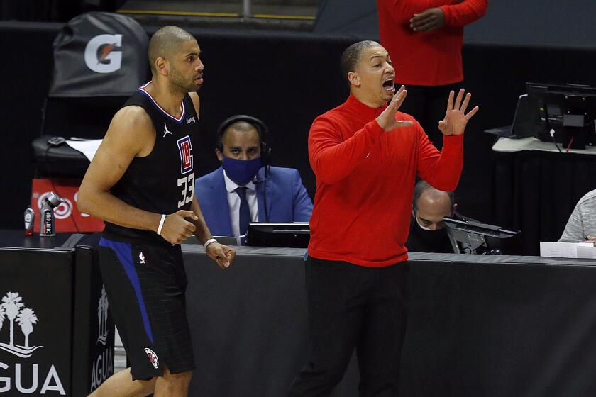 Clippers coach Tyronn Lue yells instruction as forward Nicolas Batum heads up court during a game this season.