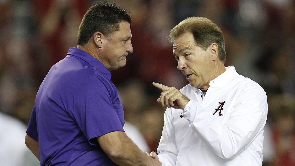 Alabama coach Nick Saban, right, and LSU coach Ed Orgeron meet in the center of the field before a game, in Tuscaloosa, Ala. on Nov. 4, 2017. Alabama and LSU face off on Saturday in Baton Rouge, La.