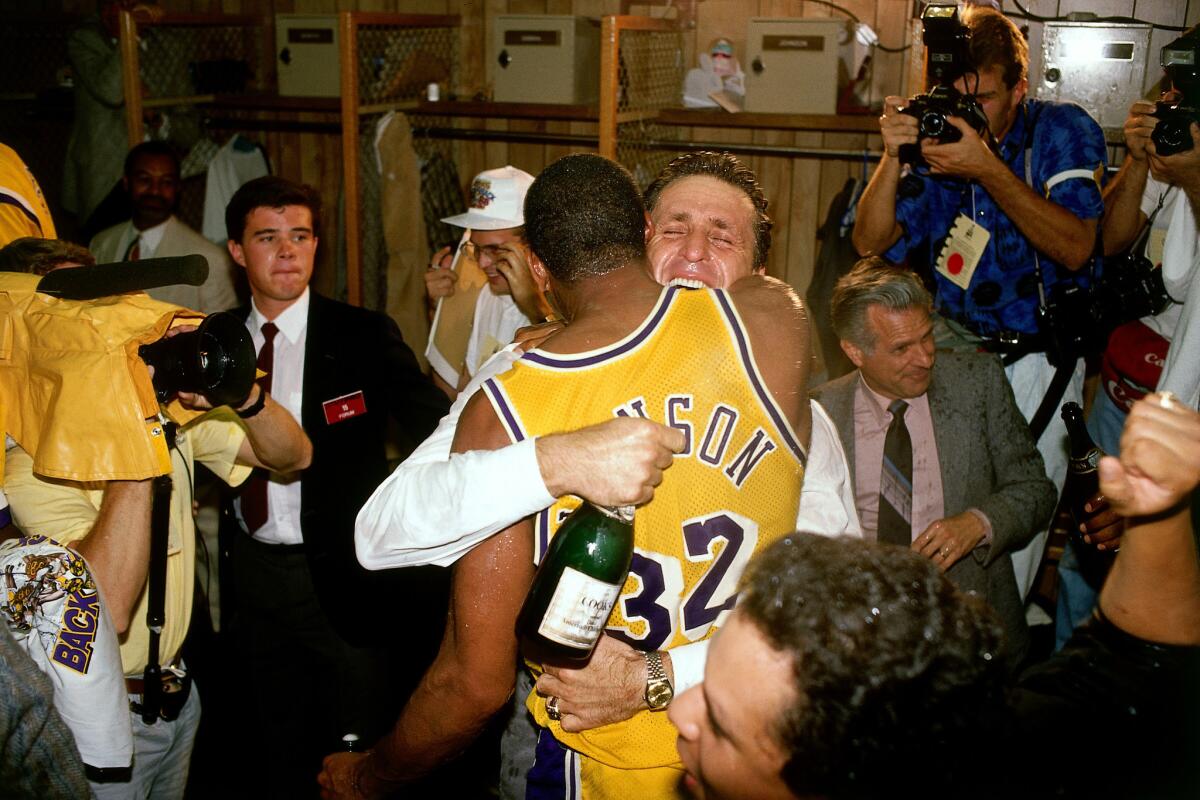 Lakers star Magic Johnson embraces coach Pat Riley during the locker-room celebration after winning the 1988 NBA title.