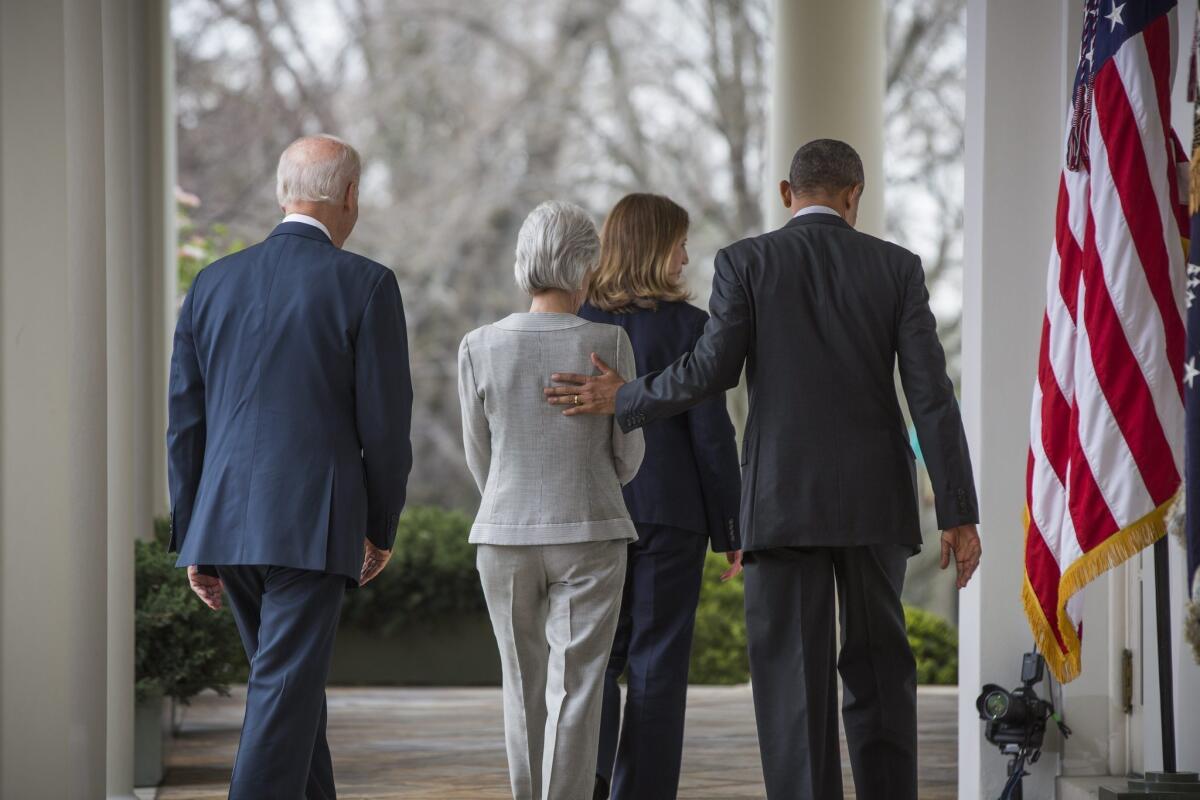 Outgoing Health and Human Services Secretary Kathleen Sebelius (in gray) and nominated successor, Sylvia Mathews Burwell, flanked by Vice President Biden and President Obama after Friday's announcement of the changeover.