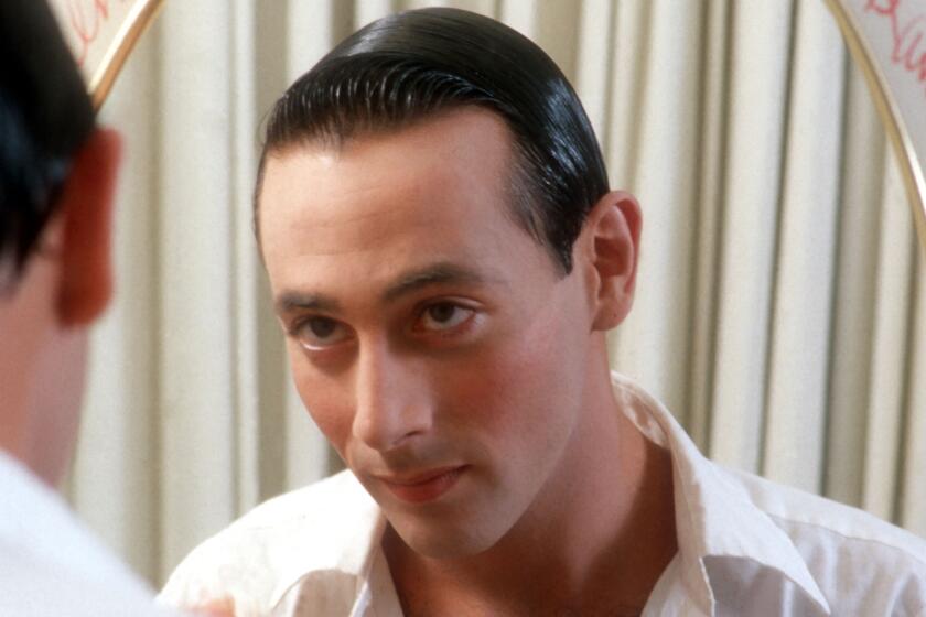 Paul Reubens as Pee-wee Herman, looking in the mirror.