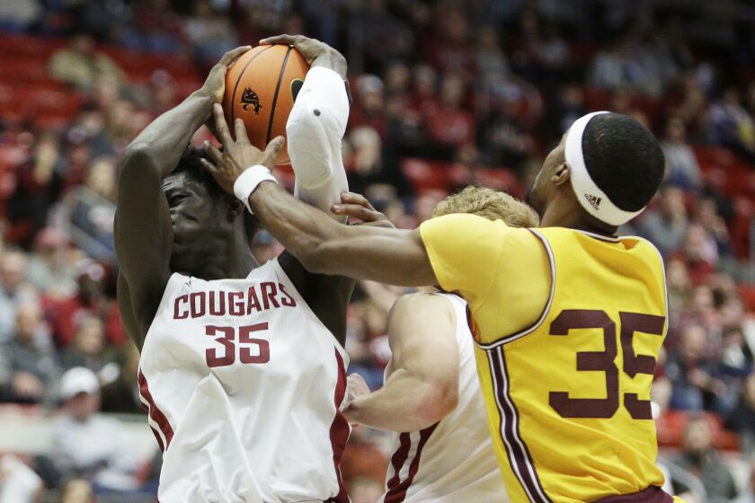 Washington State forward Mouhamed Gueye, left, grabs a rebound next to Arizona State guard Devan Cambridge during the second half of an NCAA college basketball game, Saturday, Jan. 28, 2023, in Pullman, Wash. (AP Photo/Young Kwak)